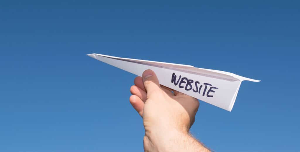Paper airplane with website written on it